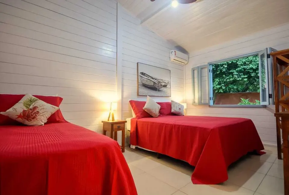 Quarto com ar-condicionado e duas camas vermelhas