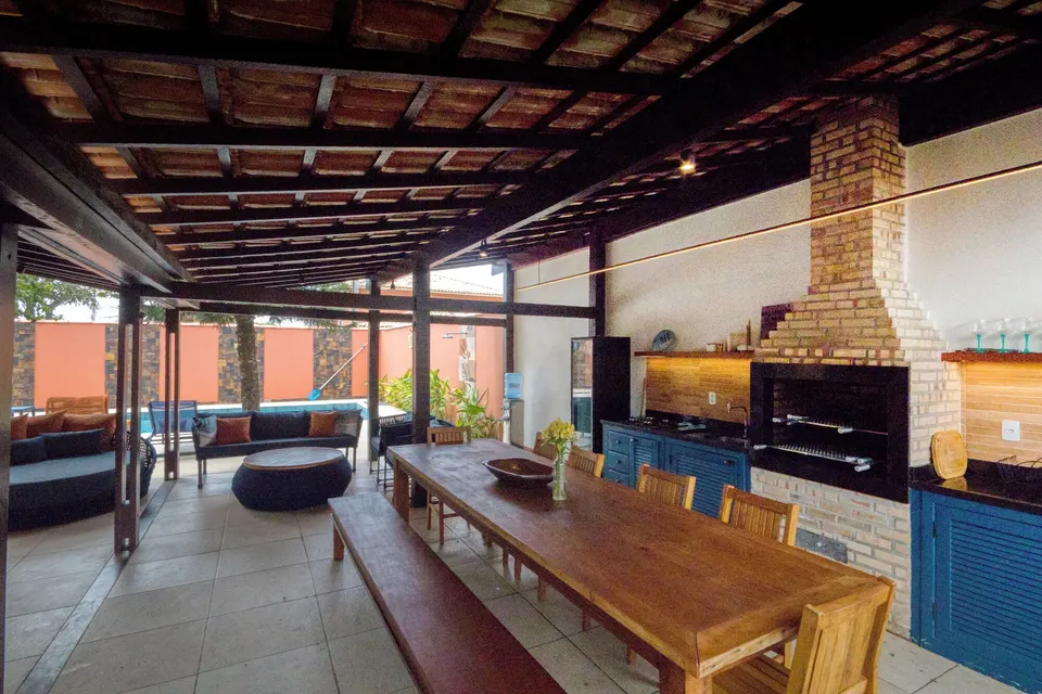 Pavilhão coberto com churrasqueira e mesa coletiva longa